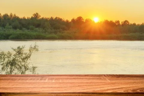 Empty wooden table with summer background of riverside at sunset. Can be used Foto stock