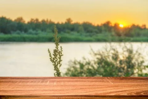 Empty wooden table with summer background of riverside at sunset. Can be used Stock Photos