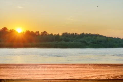 Empty wooden table with summer background of riverside at sunset. Can be used Stock Photos