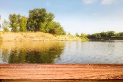 Empty wooden table with summer background of riverside in the daytime for dis Stock Photos