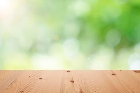 Empty wooden table top with blurred defocus natural green bokeh background, a Foto stock