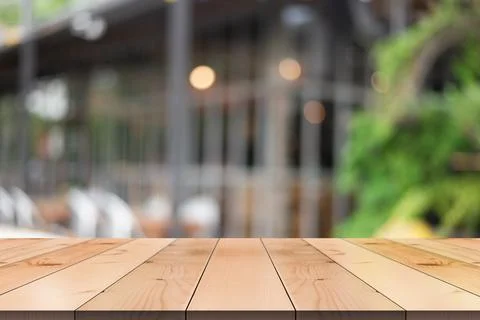 Empty wooden table top with lights bokeh on blur restaurant background. Stockillustratie