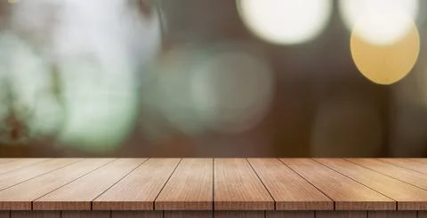 Empty wooden table top with lights bokeh on blur restaurant background. Photos
