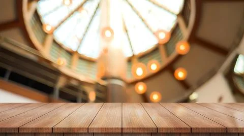 Empty wooden table top with lights bokeh on blur restaurant background. Photos