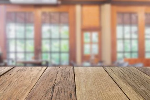 Empty wooden table top perspective with blur coffee shop background Photos