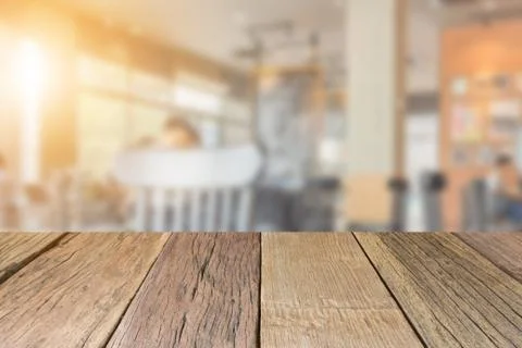 Empty wooden table top perspective with blur coffee shop background 写真素材