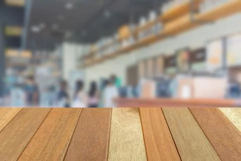 Empty wooden table top perspective with blur coffee shop background Photos