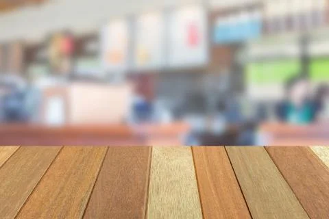 Empty wooden table top perspective with blur coffee shop background 写真素材