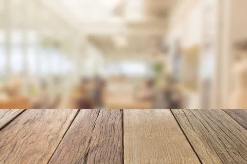 Empty wooden table top perspective with blur coffee shop background 写真素材