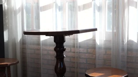 Empty Wooden Table by Window with Sheer Curtains and Soft Natural Sunlight Video stock 325236569