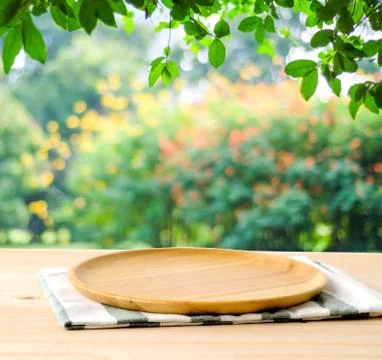 Empty wooden tray on table over blur green park background, food display mo.. Stock Photos