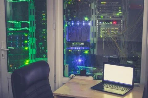 Empty workplace of the system administrator is in the server room. Many racks Stock Photos