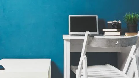 Empty workplace. Work from home. Notebook, books and pencil holder on table Stock Photos
