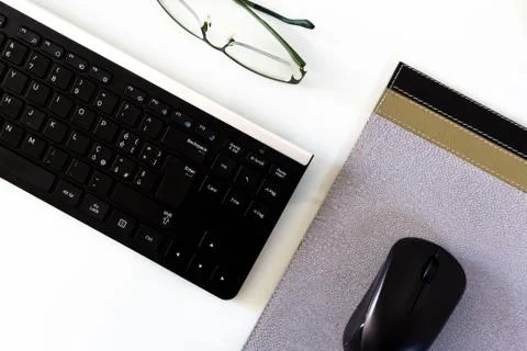 Empty workstation with keyboard, mouse, pad, and glasses detail Stock Photos