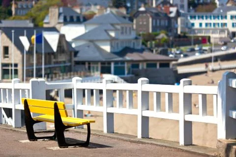 Empty yellow bench at coastline Stock Photos
