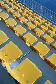 Empty Yellow Stadium Seats in Repeating Geometric Rows Stock Photos