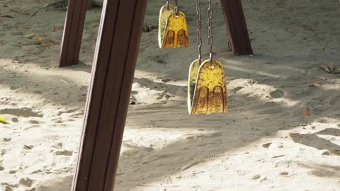 Empty yellow swing set at a playground. Pandemic coronavirus concept. Stock Footage 137073400