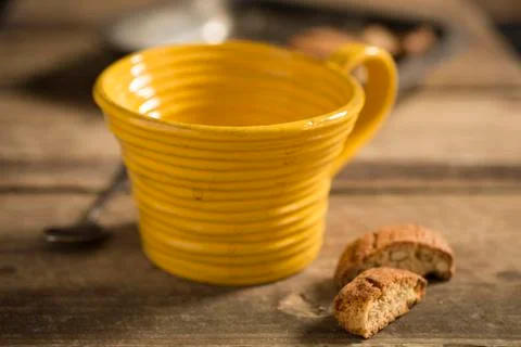 Empty Yellow Teacup Between Spoon and Biscuits Stock Photos