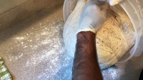 Emptying a Container of Bread Dough onto a Floured Counter Top Stock Footage 134215018