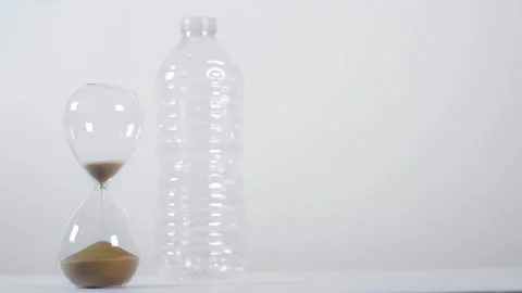 Emptying Sand Timer In Front Of Plastic Bottle Stock Footage 147686511