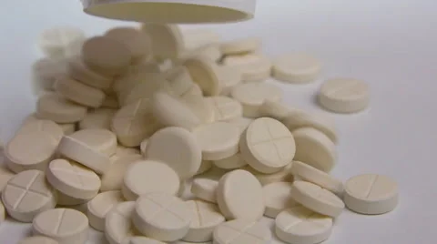 Emptying small bottle of pills on white background - beige tablets 2 Stock Footage 59866480