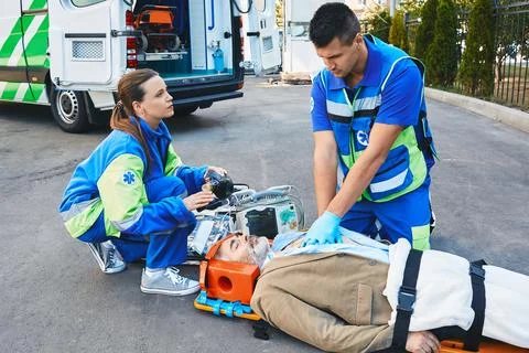 EMS, first aid. Two paramedics performing closed-chest cardiac massage for .. Stock Photos