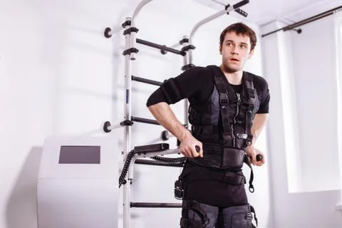 EMS male working out, doing push ups. man doing triceps dips on parallel bars Stock Photos
