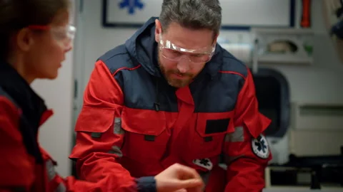 EMS paramedics preparing stretcher for emergency care Stock Footage 166909536