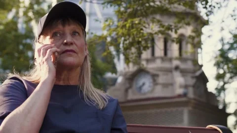 EMS worker talking on phone on park bench Stock Footage 221035282