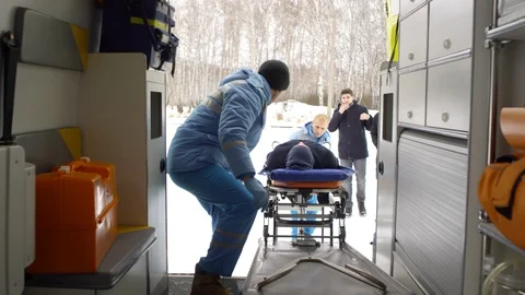 EMTs Loading Man on Stretcher into Ambulance Stock Footage