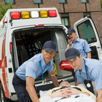 EMTs loading patient into ambulance Stock Photos