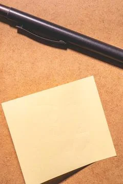 An emty sticky note on a brown background. Stock Photos