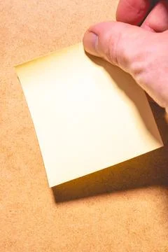 An emty sticky note on a brown background. Stock Photos