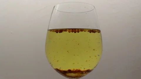 Emulsion Of Coloring Bubbles, Water Drops &amp; Sunflower Seed Oil In Wineglass Stock Footage 83007676