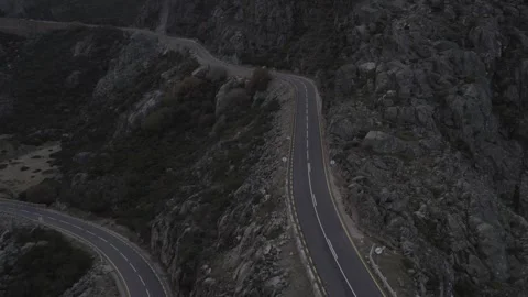 EN339 cliffside road corridor in Serra da Estrela tracked by drone pullback Stock Footage 333465114