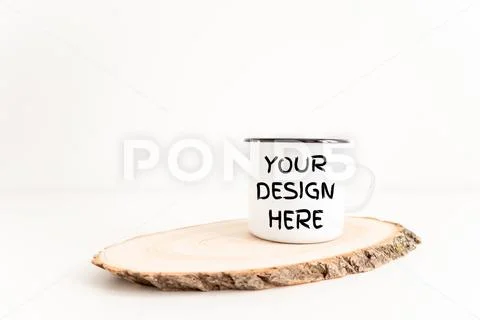 Enamel mug mock up on wooden cut tree section on white table PSD-Vorlage