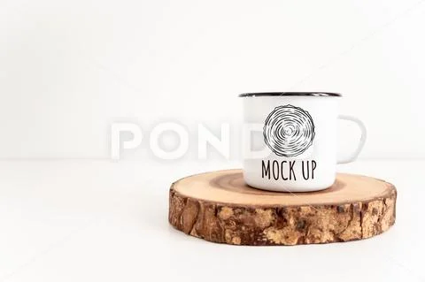 Enamel mug mock up with wooden cut tree section on white table PSD-Vorlage