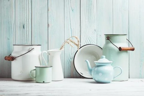 Enamelware on the kitchen table over blue wooden wall Stock Photos