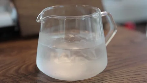 Enchanting Slow-Motion: Coffee blends with swirling water. Stock Footage 246909079