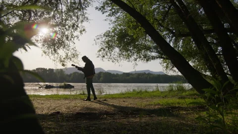 Enchanting sunset guitar performance by the river during golden hour Vídeos de archivo 319947439