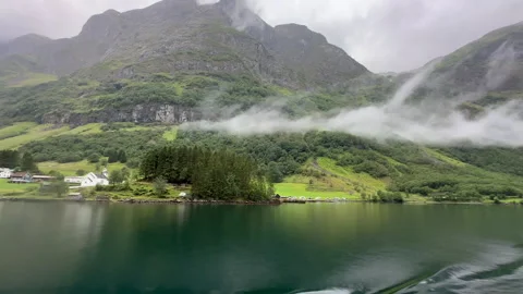 An enchanting view of mist-laden mountains reflected on serene waters Stock Footage 313951396