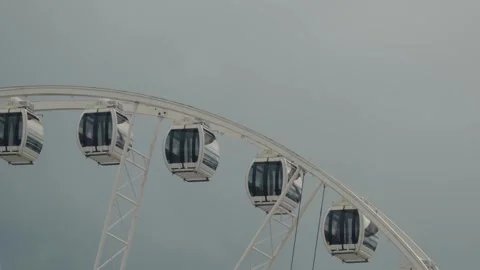 Enclosed Ferris Wheel Gondolas Against an Overcast Sky Stock Footage 343673126