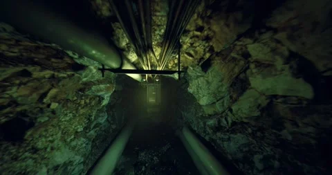 Enclosed wet passage with parallel tracks leading to bright opening in distance 库存影片 333561594