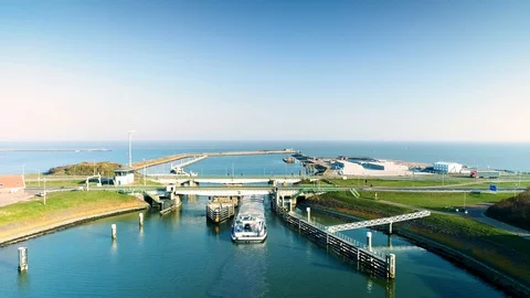 Enclosure Dam (Afsluitdijk): Cargo Ship Under Bridge - Holland – 4K Drone Stock Footage 127576021