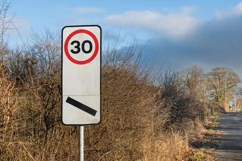 End of 30 mph speed limit sign beside roadside path Fotos de archivo
