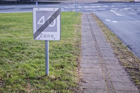 End of 40 zone sign on grass beside the city sidewalk Stock Photos