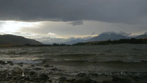 End of day light on the beach of a lake surrounded by mountains, in New Zealand Stock Footage 217402385