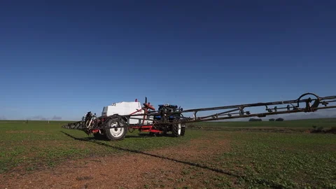 End of long spray arm swings past camera, tractor turns in crop field Stock Footage 301169597
