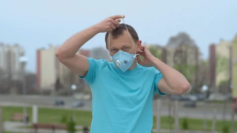 The end of self-isolation, a guy takes off his mask outdoors Stock Footage 129121936