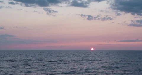 End of sunset with Purple orange luminous colors over contrasty river lake ocean Stockbeeldmateriaal 165254776